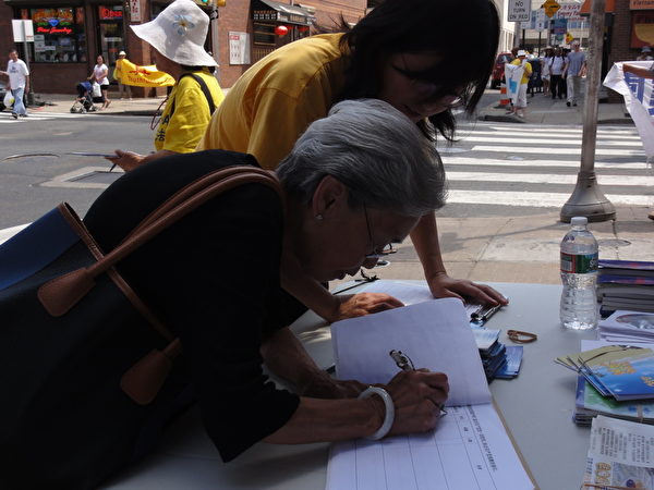 80多岁的甘阿姨是从多年前浙江温州来的。她认真地听了几位阿姨的发言后，去退党义工那里为已经过世的丈夫填写了退党声明。（司瑞/大纪元） 