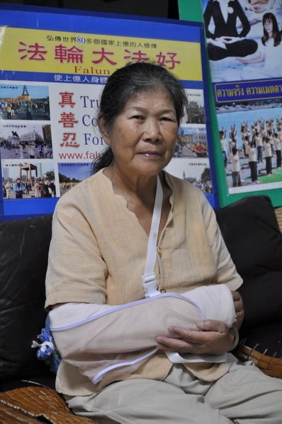 2011年10月7日，泰国学员林太太在中共驻曼谷大使前抗议遭到中共特务的暴力袭击，横幅被抢，右臂被铁棍打伤。（当事人提供） 