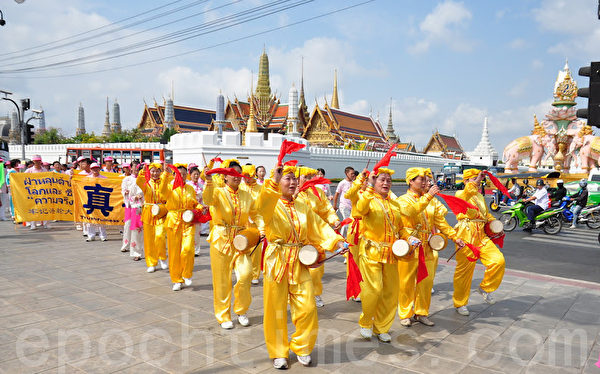 2012年3月16日，泰国法轮功学员参加，曼谷市政府举办的“84公里”步行活动庆祝泰王84岁生日的游行活动。图为游行队伍走到曼谷著名景点大皇宫外面。（摄影: 万祥顺/ 大纪元）