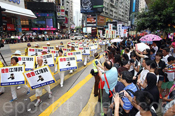 720反迫害16周年之际，香港法轮功学员7月19日在港岛举行以控告江泽民为主题的集会游行。超过八百人的游行队伍从北角前往中联办，声势浩大的场面吸引了不少中港民众驻足观看。（潘在殊/大纪元）