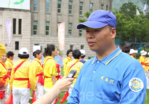 7月20日，韓國法輪功學員在首爾廣場舉行「7.20十六週年反迫害」活動。圖為華人法輪功學員王大明接受採訪。（全宇/大紀元）