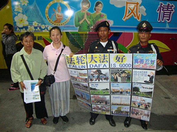 2010年，善良的泰國城管與法輪功學員一起打真相展板。（大紀元）