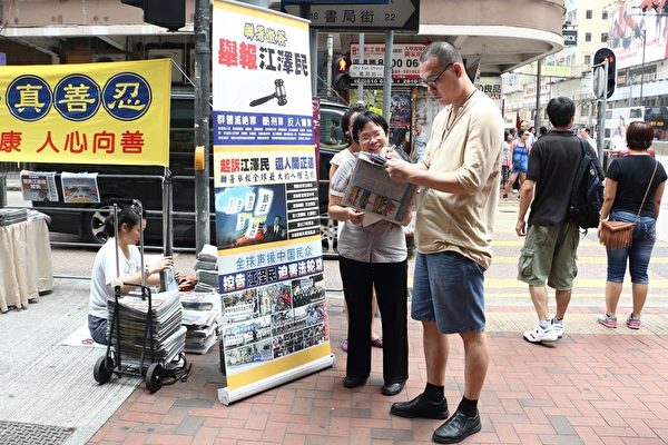 香港法轮功学员小红满脸笑容讲真相，赢得不少人签名举报江泽民。（明慧网）