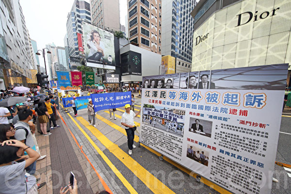 十月一日是中華國殤日，部分香港法輪功學員舉行「法辦元凶、停止迫害」的集會遊行，途中許多大陸遊客被遊行的場面震撼。（潘在殊/大紀元）