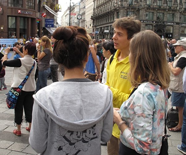 二零一五年九月十九日，在维也纳斯特凡大教堂前广场（Stephansplatz）上，拉托维亚法轮功学员瑞蒙（Raymond）在广场上人群中发传单讲真相。（明慧网）