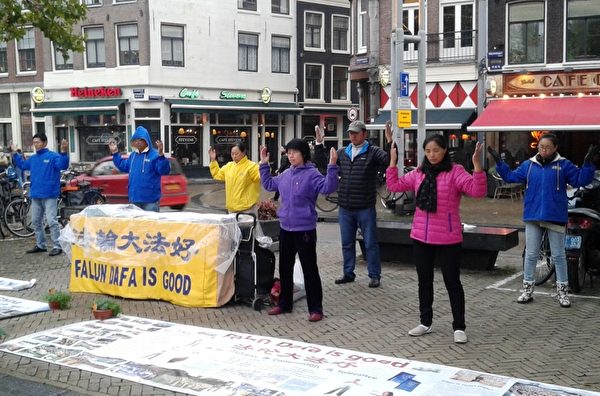 荷兰部分法轮功学员在阿姆斯特丹唐人街举办讲真相活动，演示法轮功功法。（明慧网） 
