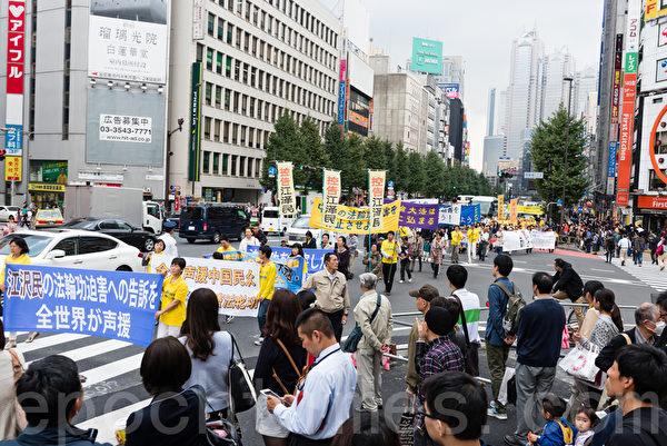 11月7日，日本法輪功學員在東京新宿的商業繁華區舉行遊行，及徵集舉報江澤民的聯署活動。許多日本民眾簽名支持，有中國遊客當場表示退出中共的黨團隊組織。（游沛然／大紀元）