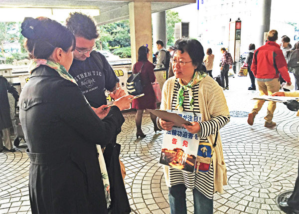 日本各地的法轮功学员在街头向日本民众讲述法轮功受迫害的真相，声援控江。图为东京的法轮功学员在新宿车站进行联署举报江泽民活动。（大纪元图片）