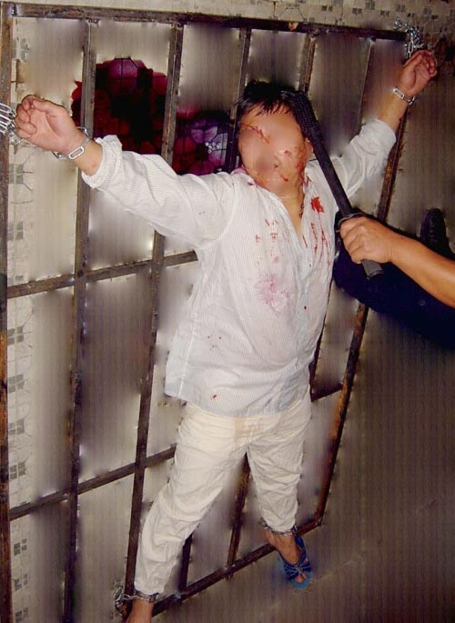 酷刑演示：法轮功学员呈“大”字形被铐在铁架子上电击。（明慧网）