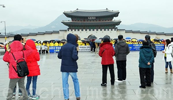 記者會期間，來韓中國遊客們駐足觀看。（金國煥／大紀元）
