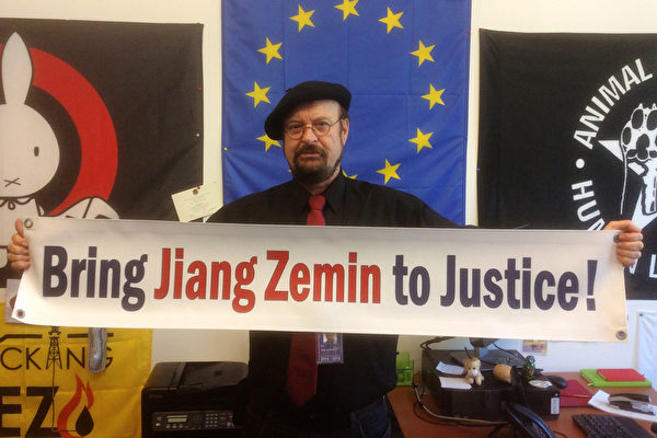 欧洲议会议员斯蒂芬‧埃克（Stefan Eck）手举“法办江泽民！”的横幅。（大纪元）
