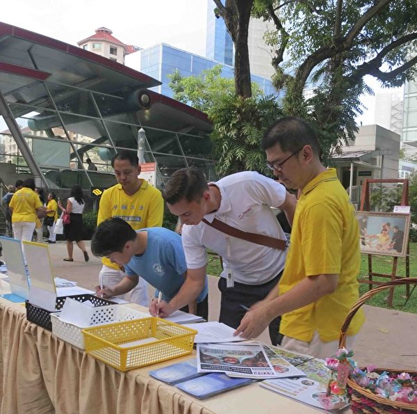在2015年12月14日活动当天，有不少新加坡人、在新加坡工作的各国人士以及来自外国的游客在刑事举报江泽民的联署书上签名。（苏每善 / 大纪元）
