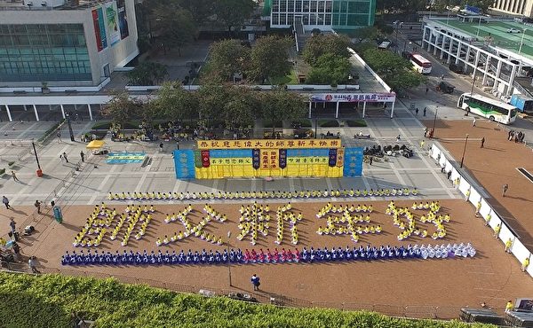 香港及来自其他国家和地区的部分法轮功学员、数百人新的一年一大早聚集在中环爱丁堡广场，身穿黄白炼功服排出“师父新年好”五个大字，向法轮功创始人李洪志先生恭祝新年快乐。（大纪元）
