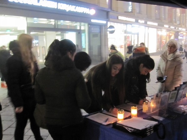 芬蘭部分法輪功學員在1月27日反酷刑紀念日，在首都赫爾辛基市中心舉辦燭光守夜悼念活動，許多民眾在得知中共迫害的真相後紛紛簽名支持起訴中共惡首江澤民。（李樂／大紀元）