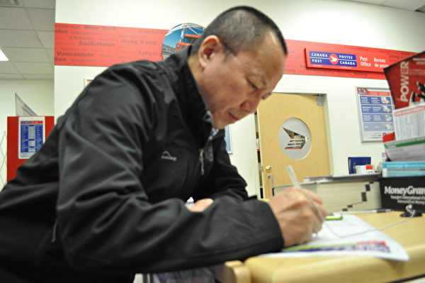 李建峰在溫哥華郵局填寫投遞到中共高檢的信件地址，加入控告江澤民的大潮中。（唐風/大紀元）