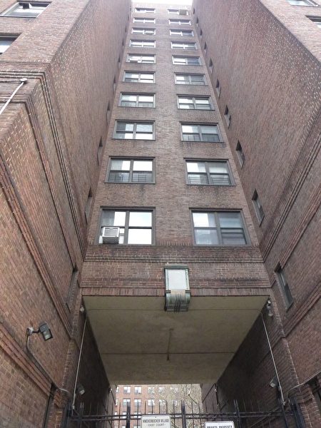 男子据信从12层楼的窗台跳出，落在了尼克村东侧楼群的后院，距离入口处不远。(蔡溶/大纪元)