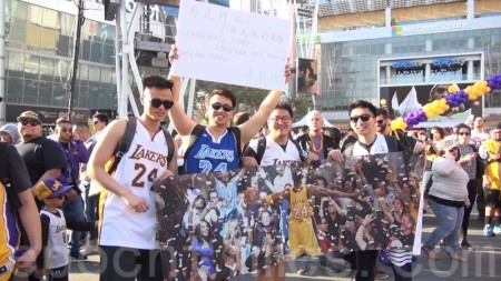 几位中国球迷手上拿着“再见科比，不再见我的青春”海报与科比告别。（薛文/大纪元）