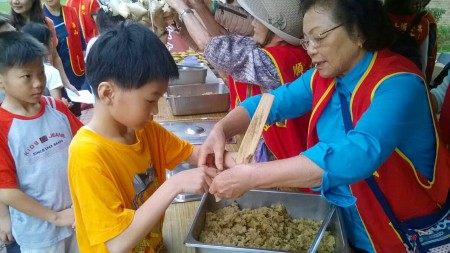 小朋友向长辈学习包粽子。（六家国小提供） 