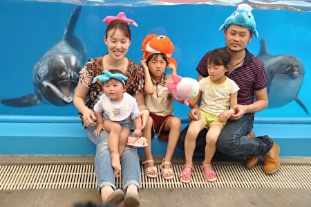 來自宜蘭的親子團遊園區，媽媽說每年逢母親節，都會帶小朋友來看小海豚，非常開心。而海豚媽媽寶妹(左)帶著小海豚(右)在水裏悠遊，與大小朋友合照，也樂開懷笑著。（詹亦菱／大紀元）