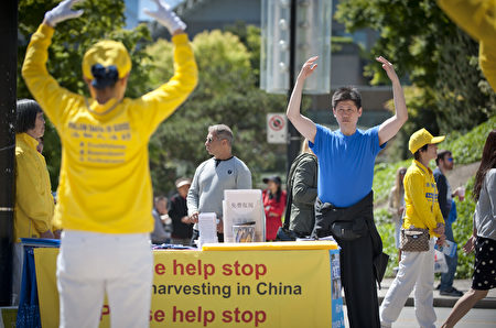 溫哥華藝術館前，溫哥華法輪功學員在表演歡快活潑的傳統腰鼓，來歡慶世界法輪大法日。（攝影：大宇/大紀元）