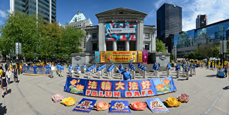 溫哥華部分法輪功學員彙集在藝術館前慶祝法輪大法日。圖正中，一排法輪功學員手中在展示卑詩省的國會議員和市長們發來的賀信和褒獎狀。（攝影：大宇/大紀元）