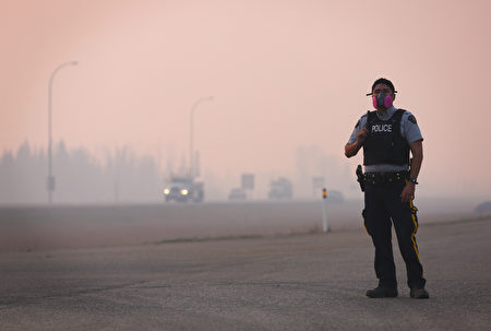 加拿大阿爾伯塔省麥克默里堡（Fort McMurray）自上週日起遭遇被稱為「野獸」的大火侵襲，目前火勢依然處於擴大趨勢。官方預計，本週六（5月7日）晚，野火將隨著大風蔓延，影響範圍將增加一倍。(COLE BURSTON//AFP/Getty Images)