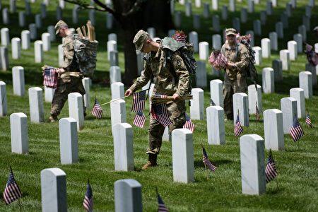 Members of the US Army place American flags at graves at Arlington National Cemetery May 26, 2016 in Arlington, Virginia in preparation for Memorial Day. / AFP / Brendan Smialowski (Photo credit should read BRENDAN SMIALOWSKI/AFP/Getty Images)