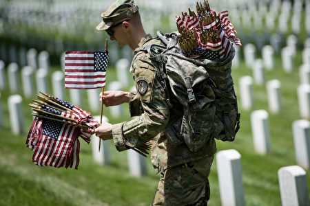 Members of the US Army place American flags at graves at Arlington National Cemetery May 26, 2016 in Arlington, Virginia in preparation for Memorial Day. / AFP / Brendan Smialowski (Photo credit should read BRENDAN SMIALOWSKI/AFP/Getty Images)