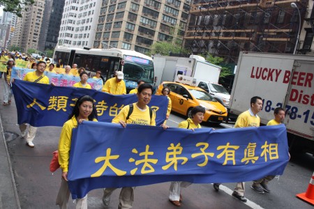 2016年5月13日，紐約上萬人遊行慶祝第17屆法輪大法日。有學員舉著橫幅：「人類等待的來了，大法弟子有真相」。（馬有志／大紀元）