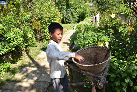 T在莫里农，无论是蹒跚学步的孩子还是耄耋老人都把美化村庄当成了日常事务。（AFP PHOTO / BIJU BORO）