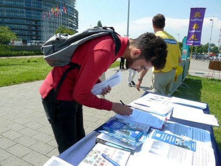 斯特拉斯堡歐洲議會大樓外，民眾簽名支持法輪功反迫害。（明慧網）