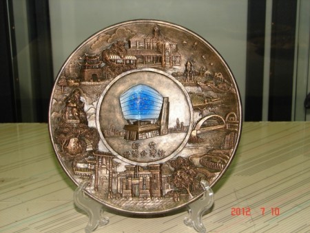 張炳鈞設計的藝品，新竹市八景浮雕圓盤，圍繞中間複合材質的台灣館。（張炳鈞提供） 