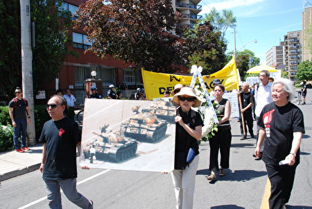 6月4日，多伦多华人在在游行过程中，手持花圈和“六.四”勇士挡坦克图片的民众走在队伍前端。（伊铃/大纪元）