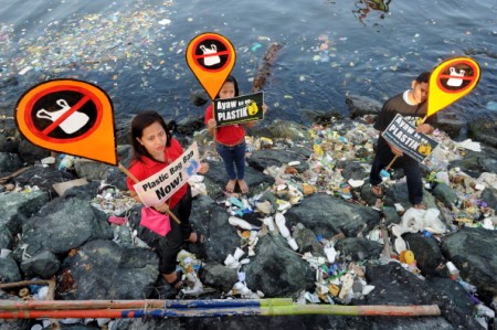 Environmental activists and volunteers hold placards calling for a ban of the use of plastic bags in Manila on July 3, 2014. Volunteers from various environmental advocates collected and separated assorted plastic rubbish polluting Manila Bay and called for national legislation against plastic bags in observance of the 5th International Plastic Bag-Free Day on July 3. AFP PHOTO / Jay DIRECTO (Photo credit should read JAY DIRECTO/AFP/Getty Images)