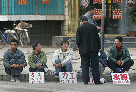 2002年10月8日遼寧的失業工人在路邊等著雇主僱他幹零工。 (FREDERIC J. BROWN/AFP/Getty Images)