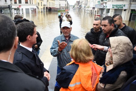 French Prime minister Manuel Valls (L) listens to a victim of floods during a visit of Nemours after the Loing river burst its banks and forced residents to be evacuated in Nemours, some 80km south of Paris, on June 2, 2016. Torrential downpours have lashed parts of northern Europe in recent days, leaving four dead in Germany, breaching the banks of the Seine in Paris and flooding rural roads and villages. AFP PHOTO /LIONEL BONAVENTURE / AFP / LIONEL BONAVENTURE (Photo credit should read LIONEL BONAVENTURE/AFP/Getty Images)