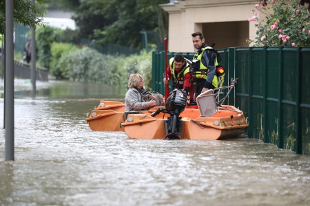 Firefighters rescue a woman in a flooded street with their small boat after the Yvette river burst its banks and forced residents to be evacuated in Longjumeau, some 20kms south of Paris, on June 2, 2016. Torrential downpours have lashed parts of northern Europe in recent days, leaving four dead in Germany, breaching the banks of the Seine in Paris and flooding rural roads and villages. AFP PHOTO /KENZO TRIBOUILLARD / AFP / KENZO TRIBOUILLARD (Photo credit should read KENZO TRIBOUILLARD/AFP/Getty Images)