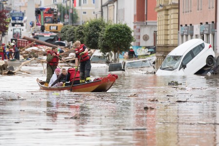 SIMBACH AM INN, GERMANY - JUNE 02: Firemen rescue two women with their boat following heavy floods the day before on June 2, 2016 in Simbach am Inn, Germany. Flash floods from the swollen Inn river took local communities by surprise, trapping children at schools and forcing some residents to flee to their rooftops. Floods have hit scattered communities across southern Germany in the past week leaving four people dead. (Photo by Sebastian Widmann/Getty Images)