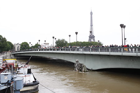 PARIS, FRANCE - JUNE 03: People watch the flood water level of Seine river from Pont de l'Alma bridge with the partially submerged statue 'Le Zouave' on June 03, 2016 in Paris, France. Northern France is experiencing wet weather causing flooding in parts of France especially in Paris. (Photo by Thierry Chesnot/Getty Images)
