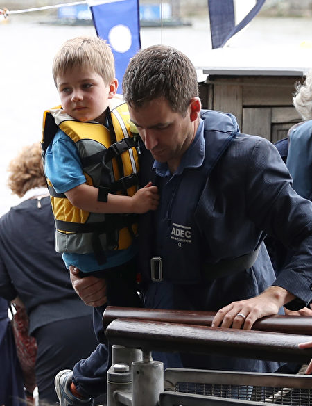 2016年6月22日，英国伦敦，英国遇刺女议员乔·考克斯的丈夫 Brendan Cox抱着儿子Cuillin 登船。(LEON NEAL/AFP/Getty Images)