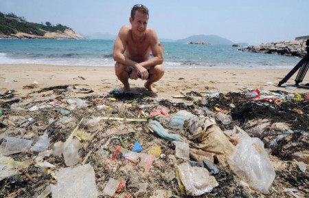 TO GO WITH Environment-US-Asia-ocean-waste-plastic,FEATURE by Guy Newey Doug Woodring, an entrepreneur and conservationist who lives in Hong Kong, looks at rubbish on May 07, 2009 on a beach on the south side of Hong Kong which has been left uncleaned. A group of conservationists and scientists is due to set sail for an obscure corner of the Pacific Ocean in the coming months to explore a vast swirl of waste known as the "Plastic Vortex." The giant gloop -- which some scientists estimate is twice the size of Texas -- has been gradually building over the last 60 years as Asia and the United States tossed their unwanted goods into the ocean. AFP PHOTO/MIKE CLARKE (Photo credit should read MIKE CLARKE/AFP/Getty Images)
