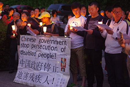 張廣利（中）帶來為中國殘疾人呼籲的標語。（劉菲/大紀元）