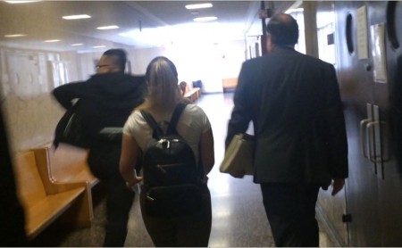 林丹尼（左）在女朋友和辩护律师的保护下，飞快跑出法庭，躲避记者。