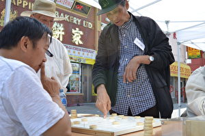 卡城中國象棋大師亮相活動現場，與遊客切磋棋藝。(黃鐘樂/大紀元）
