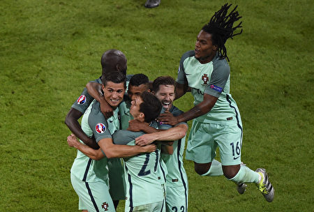 2016年欧洲杯第一场半决赛7月6日在里昂球场展开争夺，葡萄牙队以2球轻取威尔斯。图为葡萄牙前锋C罗（左）得分后和队友拥抱。(PHILIPPE DESMAZES/AFP)