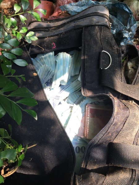 警方20日在北市内湖区西湖公园上的一处小山丘，找到装有赃款的黑色手提袋。（警方提供）