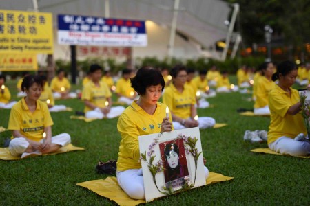 圖為參加紀念720集會的新加坡部分法輪功學員燭光悼念被中共迫害致死的同修。（Tony/大紀元）