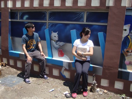 遊客來到「喵星人的愛情故事」3D彩繪牆合影留念，有如搭地鐵的真實感。（蔡上海／大紀元）