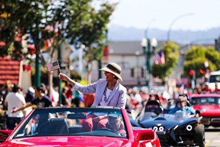 A woman on a car waves an American flag while riding through the 4th of July Parade, in Alameda, California on Monday, July 4, 2016. / AFP / GABRIELLE LURIE (Photo credit should read GABRIELLE LURIE/AFP/Getty Images)