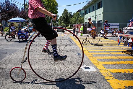 TOPSHOT - A man wears decorative socks while riding a vintage bicycle during the 4th of July Parade in Alameda, California on Monday, July 4, 2016. / AFP / GABRIELLE LURIE (Photo credit should read GABRIELLE LURIE/AFP/Getty Images)